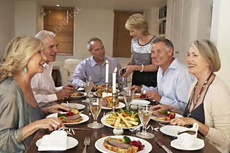 Friends Seated At Table For A Dinner Party