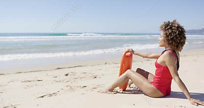 Female with rescue float sitting on beach
