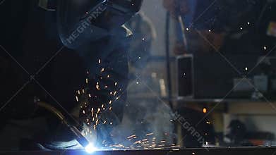 Welder in Equipment Works with Welding Machine
