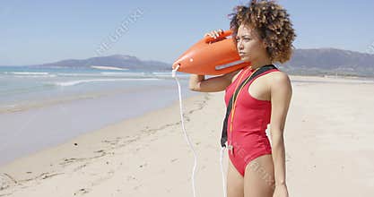 Lifeguard blowing a whistle holding rescue float