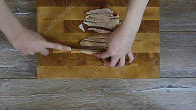 Female hands cut chicken breast