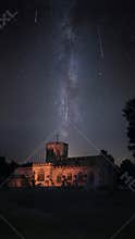 Illuminated church with milky way night sky during Perseid meteor shower