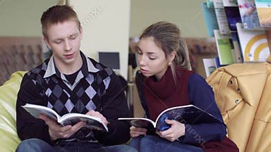 College students reading magazines in library