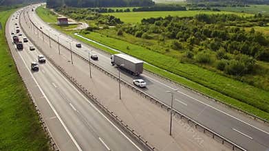 Beautiful aerial view of highway with riding trucks and cars in the countryside