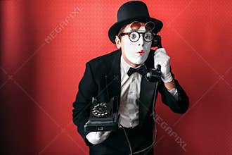 Mime theater actor performing with old telephone
