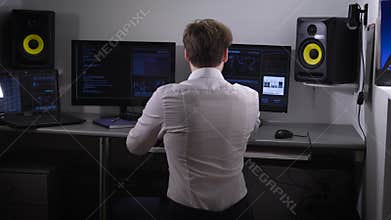 Young software developer analyzes and introduces a large amount of electronic data while working on a new software