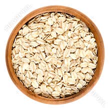 Oatmeal, rolled oats in wooden bowl over white