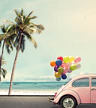 Car with colorful balloon on beach blue sky