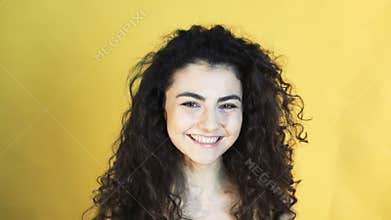 Cheerful girl shows emotion of reconciliation on yellow background 4K