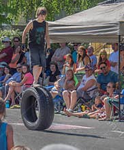 Boy walks on rolling tire in parade