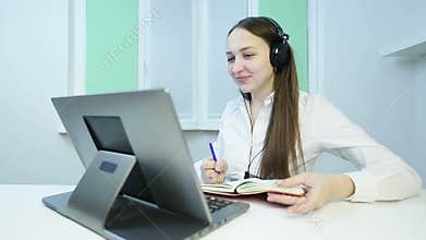 Young business woman with headphones carries a meeting on the video call.