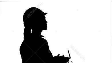 Silhouette Female engineer operating a drone analyzing object.