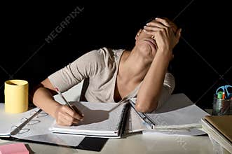Spanish girl studying tired and bored at home late night looking sad and stressed preparing exam