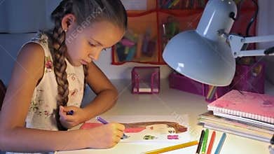 Girl coloring a drawing at the desk