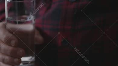 Adult male taking pills and drinks water