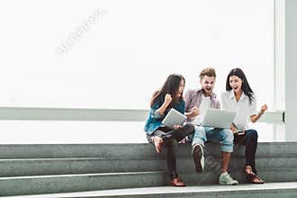 Multiethnic group of college students or freelance coworkers celebrate together with laptop and tablet. Creative or business team