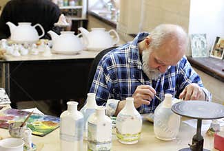 The artist painting ceramic bottles