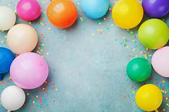 Colorful balloons and confetti on blue table top view. Festive or party background. Flat lay style. Birthday greeting card.