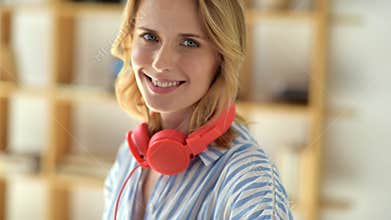 Beautiful smiling woman in headphones posing for camera