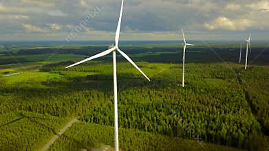 Wind turbines on forest on cloudy day