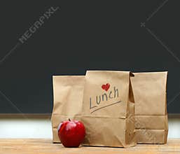 Lunch bags with apple on school desk