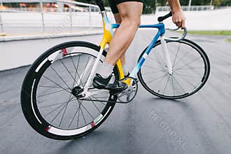 A professional cyclist rides on a beautiful and vibrant city bike. Man on a fixed bike.