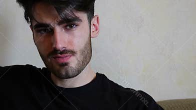 Handsome young man sitting on couch