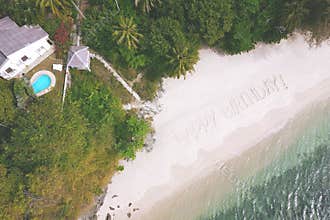 Aerial: Big Sign Happy Birthday on the Sandy Beach by the Andaman Sea in Phuket, Thailand.