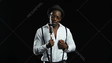 Male african american musician singing in a recording studio. Black background