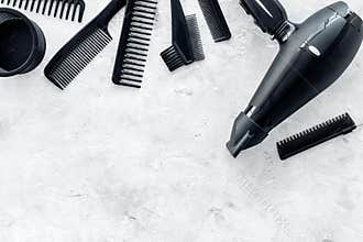 Hairdresser working desk with dryer and tools for hair styling on gray stone desk background top view mock up