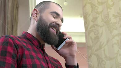 Cheerful bearded man with phone.