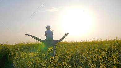 Parent with kid playing airplane on nature, son sits on shoulders father on meadow, happy dad with boy in backlight