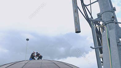 Two climbers construct something on the dome