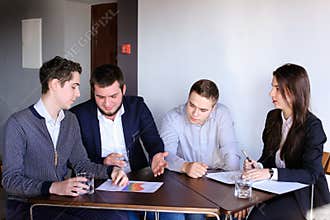 Four colleagues of man and woman gather for meeting at office of