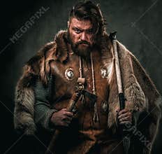 Viking with cold weapon in a traditional warrior clothes