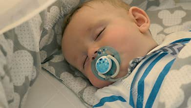 Portrait of charming baby is sleeping in a crib