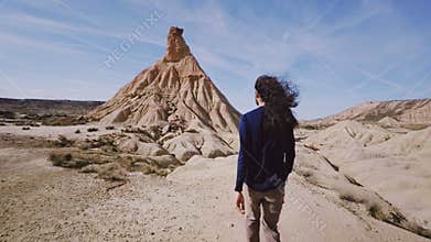 Tall traveler walks through desert on hot sunny day