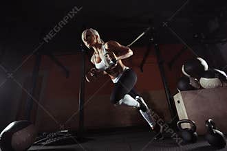 Fitness woman workout on the TRX in the gym