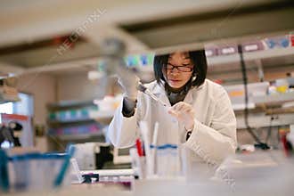 Asian Scientist Pipetting at a Biomedical Laboratory