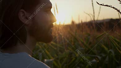 Close up of handsome man with beard with nature landscape in sunset/sunrise.