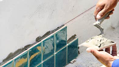 Worker plastering concrete at wall of house construction