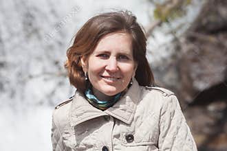 A portrait of middle age woman against waterfall