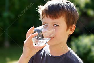 Little boy drink water in nature