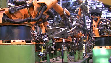Robots weld car parts in production line at factory