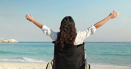 Disabled woman with arms outstretched at the beach