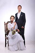Portrait of young man and woman on vintage chair retro wedding