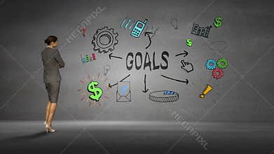 Businesswoman looking at wall with goals brainstorm