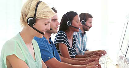 Happy call centre agents talking on the headset