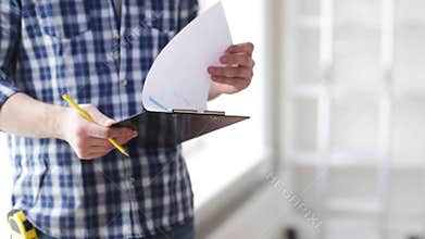 Close up of man looking and writing to clipboard