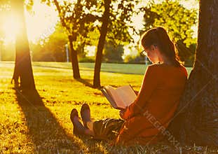 Girl reading book at park